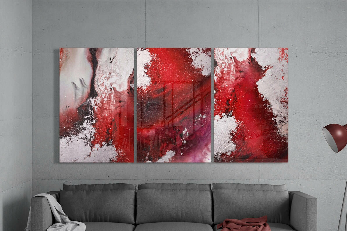 Abstract red and white painting on a gray wall above a gray sofa.
