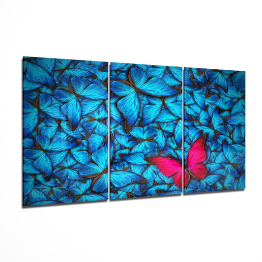 Triptych artwork of blue butterflies with a pink butterfly in the center on a white background